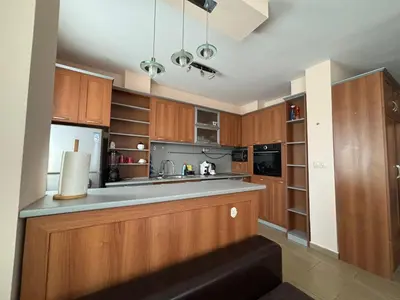 a kitchen with wooden cabinets and a counter top at Cozy 1-Bedroom Apartment Near Old Town - Purple5 in Plovdiv