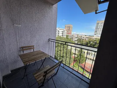 a balcony with a wooden table and bench on a building at Cozy 1-Bedroom Apartment Near Old Town - Purple5 in Plovdiv