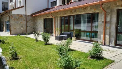 a building with a yard with plants in front of it at Stylish studio E61 in Borovets Gardens in Borovets