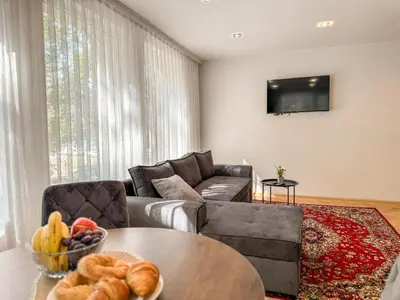 a living room with a couch and a table with a bowl of fruit at Two-Bedroom Central and Cosy Apartment in Plovdiv