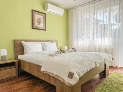 a bedroom with a large bed and a window at Two-Bedroom Central and Cosy Apartment in Plovdiv