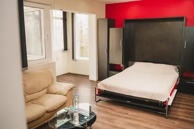 a bedroom with a bed and a couch and a table at Sunny Corner Apartment in Plovdiv