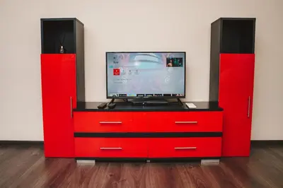 a red dresser with a tv on top of it at Sunny Corner Apartment in Plovdiv