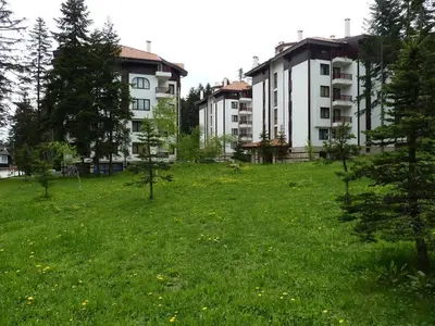 a field of green grass with buildings in the background at Private apartments in Flora Residence in Borovets