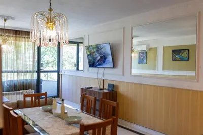 a dining room with a table and a chandelier at Megy's 3 Bedroom Central Apartment near NDK in Sofia