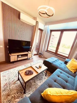 a living room with a blue couch and a television at The Bansko Retreat in Bansko