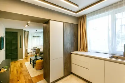a kitchen with white cabinets and a large window at Apartment in Sofia's core - NDK in Sofia