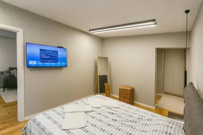a bedroom with a bed and a tv on the wall at Apartment in Sofia's core - NDK in Sofia