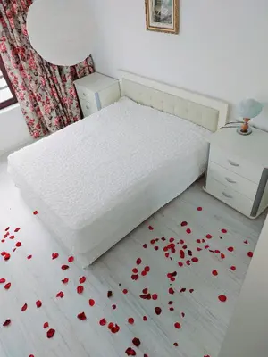 a bedroom with a bed with red flowers on the floor at Deva Apartments in Sandanski