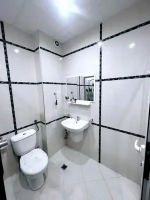 a white bathroom with a toilet and a sink at Deva Apartments in Sandanski