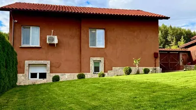 a house with a green lawn in front of it at Къща за Гости Тодор in Shiroki Dol