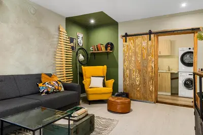 a living room with a couch and a yellow chair at Villa YASNA - Art of slow living in Sredno Gradishte