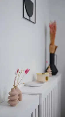 a white counter with vases and flowers on it at Fresh & Modern Apartment with Balcony by Flat Mаnager in Sofia