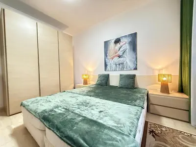 a bedroom with a large bed and a painting on the wall at Apartment Grand Monastery Pamporovo in Pamporovo