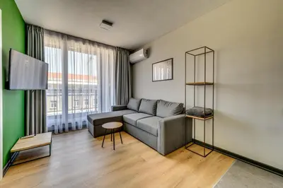 a living room with a couch and a green wall at La Shara Building in Sofia