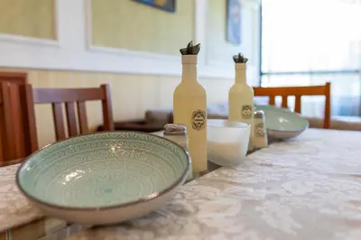a table with three bottles and plates on it at Megy's 3rd Top Central Room in Sofia