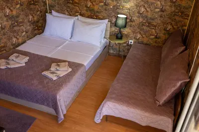 a bedroom with two beds and a couch at Megy's 1st Room next to the National Palace of Culture in Sofia