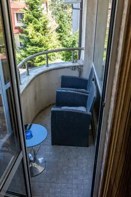 two chairs and a table on a balcony at Megy's 1st Room next to the National Palace of Culture in Sofia