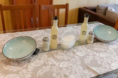 a table with three bottles and plates on it at Megy's 1st Room next to the National Palace of Culture in Sofia