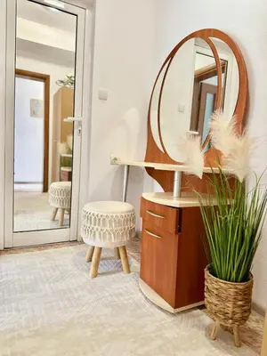a bathroom with a round mirror and a stool at The Central Suite in Petrich