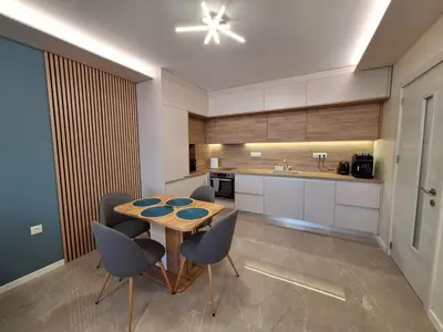 a kitchen with a wooden table and chairs at Blue Home Atana Near Airport in Sofia