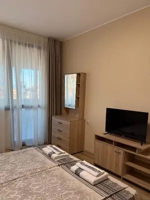 a bedroom with a large bed with a flat screen tv at Asen Tsvetkov Apartment in Sandanski