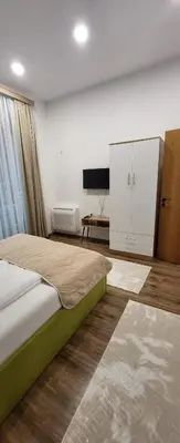a bedroom with a large bed and a television at Green apartment Velingrad in Velingrad
