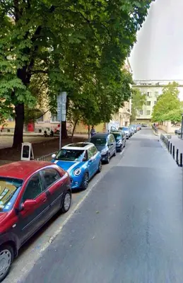 a row of cars parked on the side of a street at Big & Cozy Central Apartment in Sofia