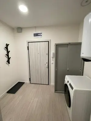 a laundry room with a washing machine and a door at Well Equipped New Family Friendly One-Bedroom Flat in Sandanski