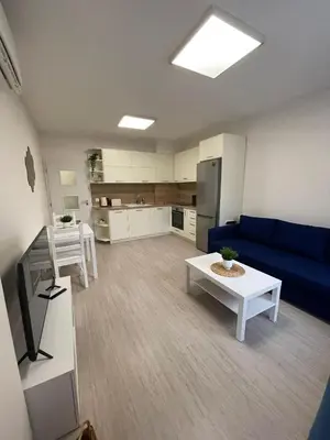 a living room with a blue couch and a table at Well Equipped New Family Friendly One-Bedroom Flat in Sandanski