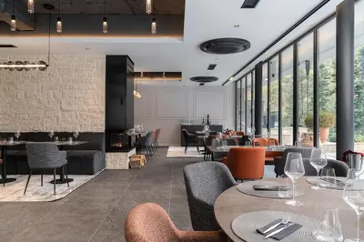 a restaurant with tables and chairs and windows at Villa Rossa Luxury & Spa Residence in Narechenski Bani
