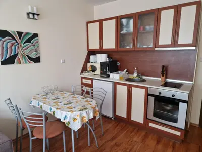 a small kitchen with a table with chairs and a sink at Cedar Heights 1 Виванко А7 in Pamporovo