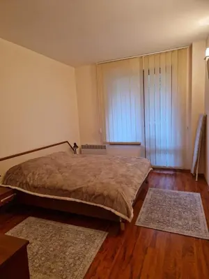 a bedroom with a bed and two rugs at Cedar Heights 1 Виванко А7 in Pamporovo