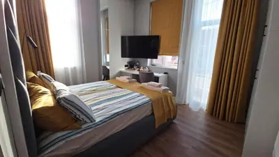 a bedroom with a bed and a television in it at FS Apartments Romantic Kapana View Room in Plovdiv