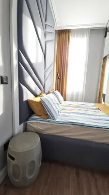 a small bedroom with a bed with a large window at FS Apartments Romantic Kapana View Room in Plovdiv