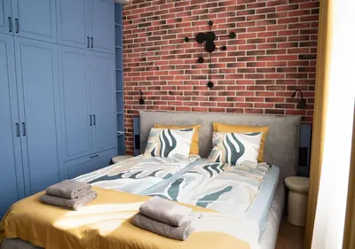a bedroom with a bed with a brick wall at FS Apartments Kapana Boutique Family Stay in Plovdiv