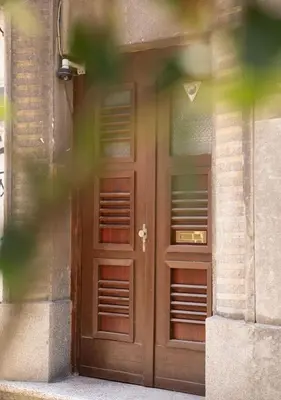 a wooden door of a building with two windows at FS Apartments Kapana Boutique Family Stay in Plovdiv