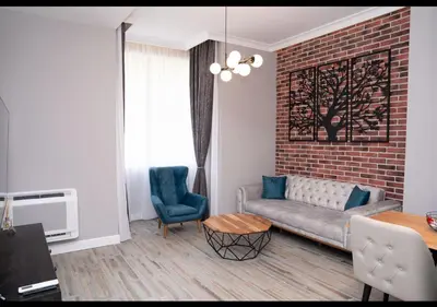a living room with a couch and a brick wall at FS Apartments Kapana Boutique Family Stay in Plovdiv