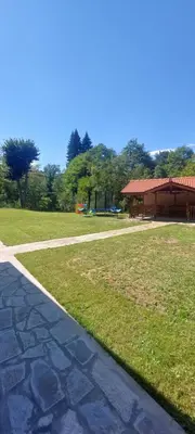 a walkway next to a grass field with a building at Двете къщи село Бели осъм in Beli Osŭm