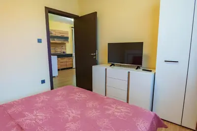 a bedroom with a bed and a tv on a dresser at Двете къщи село Бели осъм in Beli Osŭm