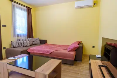 a small room with a bed and a couch at Двете къщи село Бели осъм in Beli Osŭm