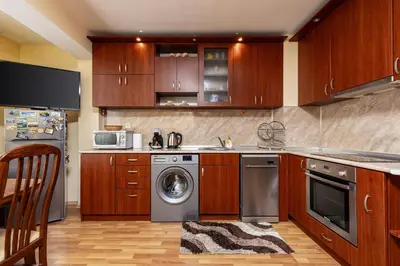 a kitchen with wooden cabinets and a washing machine at Comfort Corner - 1BD with Balcony by Flat Mаnager in Plovdiv