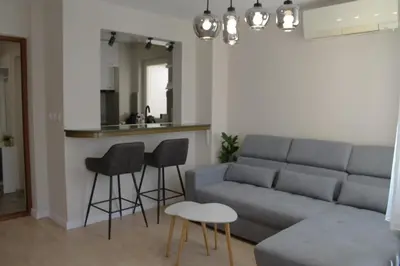 a living room with a couch and chairs and a kitchen at cosy apartment in Sofia