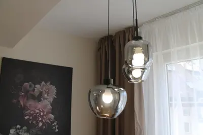 three lights hanging from a ceiling with a window at cosy apartment in Sofia