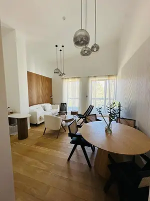 a living room with a table and a couch at White & Wood Suite C302, at Euphoria SPA Borovets in Borovets