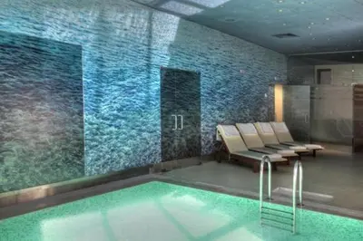 a swimming pool with a row of chairs in a building at White & Wood Suite C302, at Euphoria SPA Borovets in Borovets