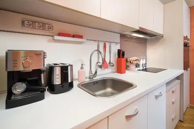 a kitchen with a sink and a coffee maker at Alexandra's City Center Apartment I in Sofia