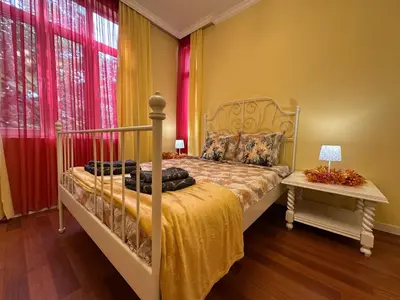 a bedroom with a bed and a table and windows at Central Family Residence in Sofia