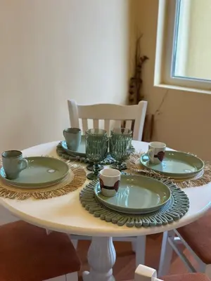a table with green plates and cups on it at Central Family Residence in Sofia