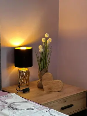 a table with a lamp and a vase of flowers at Central Family Residence in Sofia